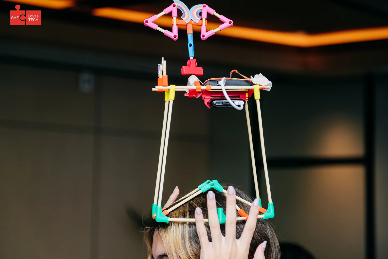 A tall chopstick tower held up by several pairs of hands