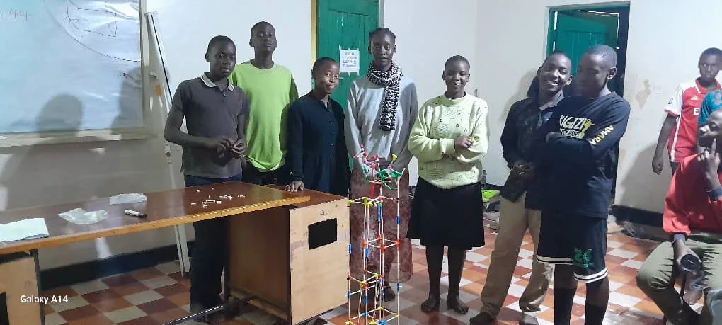 Students outdoors behind a long bench of finished builds