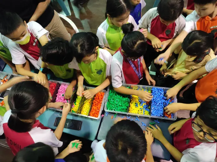 A tray of coloured connectors being passed across a table