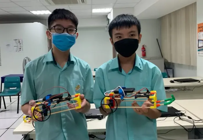 A row of finished chopstick builds on a classroom table