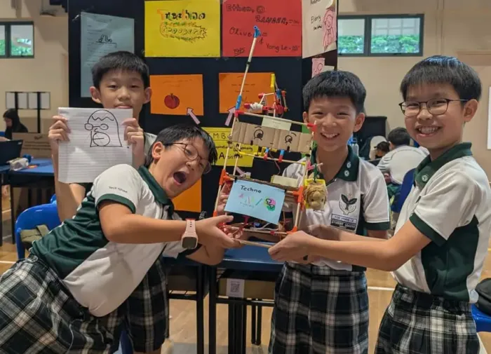 Two students fitting a connector onto a chopstick frame