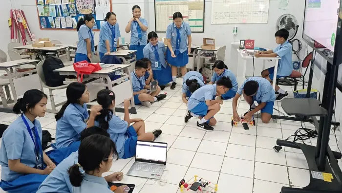 A classroom of students building with chopsticks and connectors at their desks
