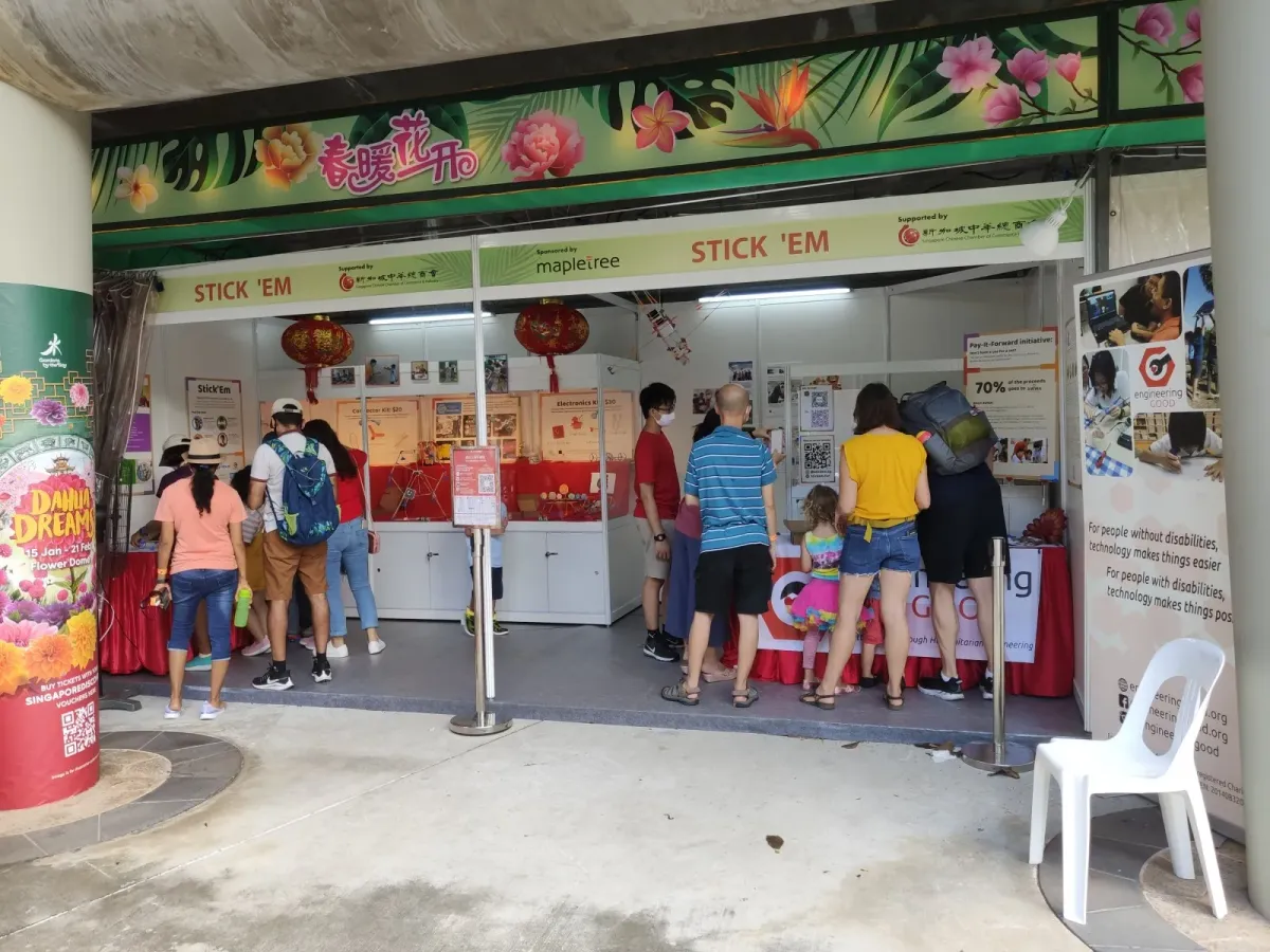 The Stick ’Em booth at the River Hongbao festival, families crowded along the counter trying the kits
