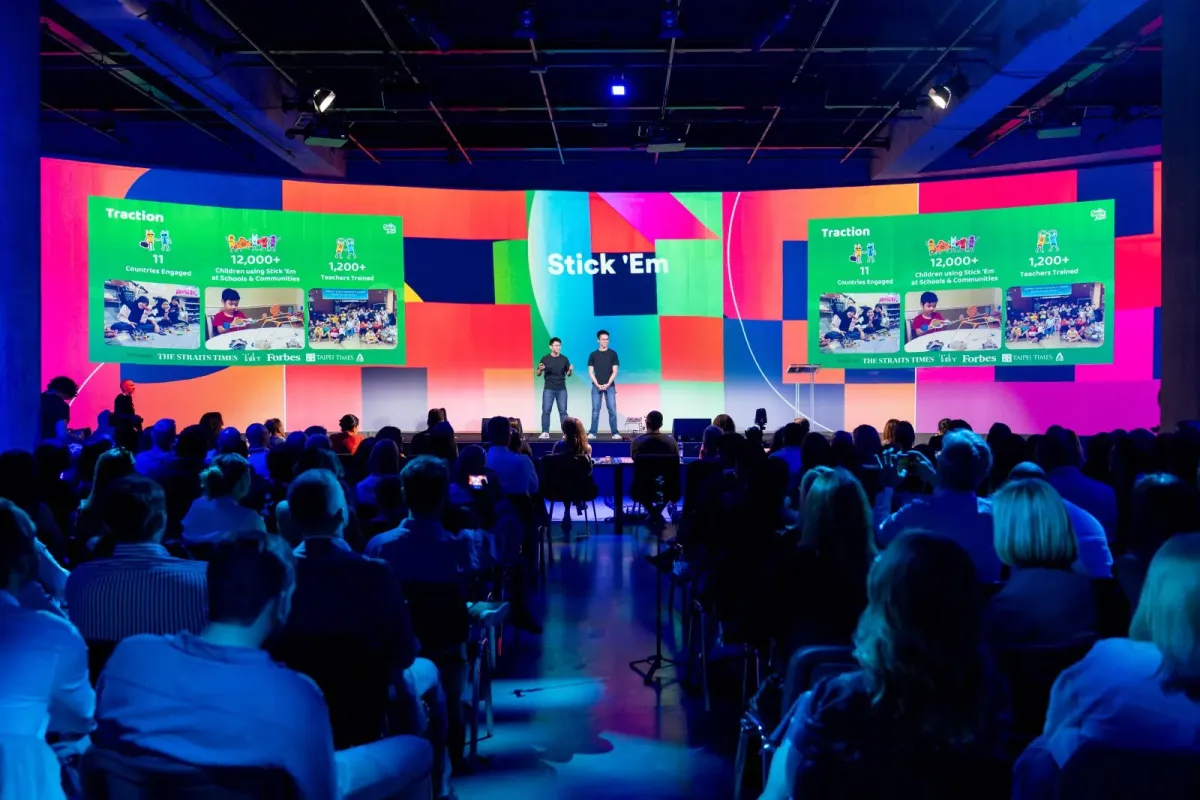 The Hult Prize global finals stage, the Stick ’Em traction slide filling the LED wall behind the team