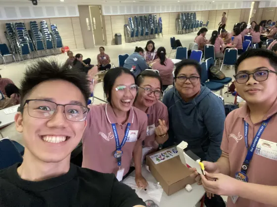 Teachers laughing over a half-built chopstick frame