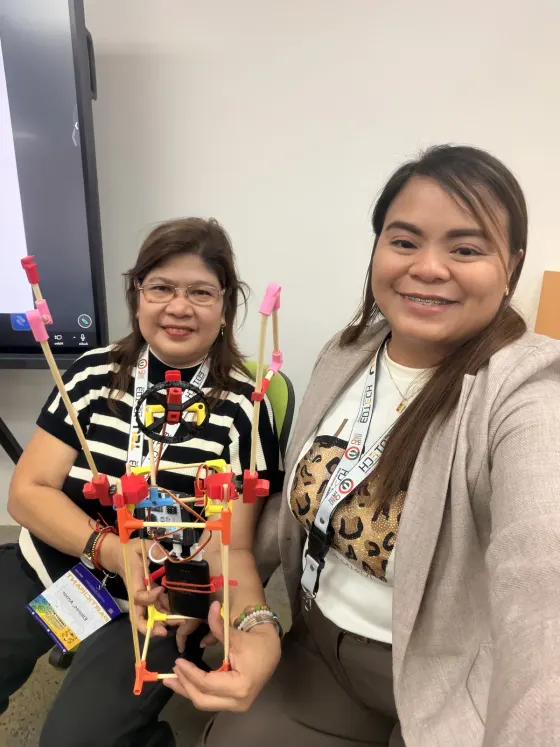 Two teachers testing a build on a table